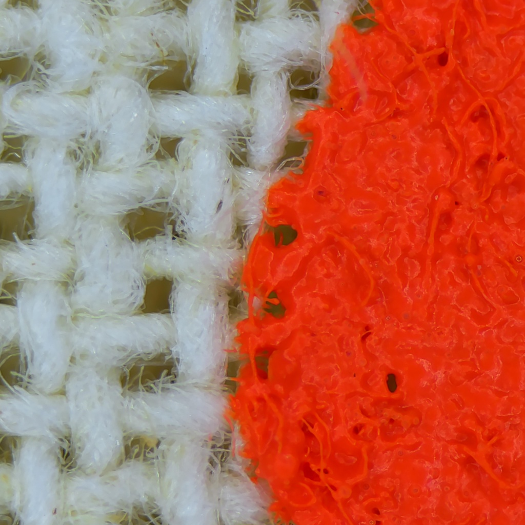 Real held-out microscope photograph of white and orange tote fibres